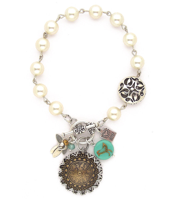 Fun, eclectic combo of antiqued brass disc, glass pearls, copper stamped bird embedded in glass bead, pewter, sterling plated brass leaves and faceted crystal beads. Hand linked. Approx 7.5" long.